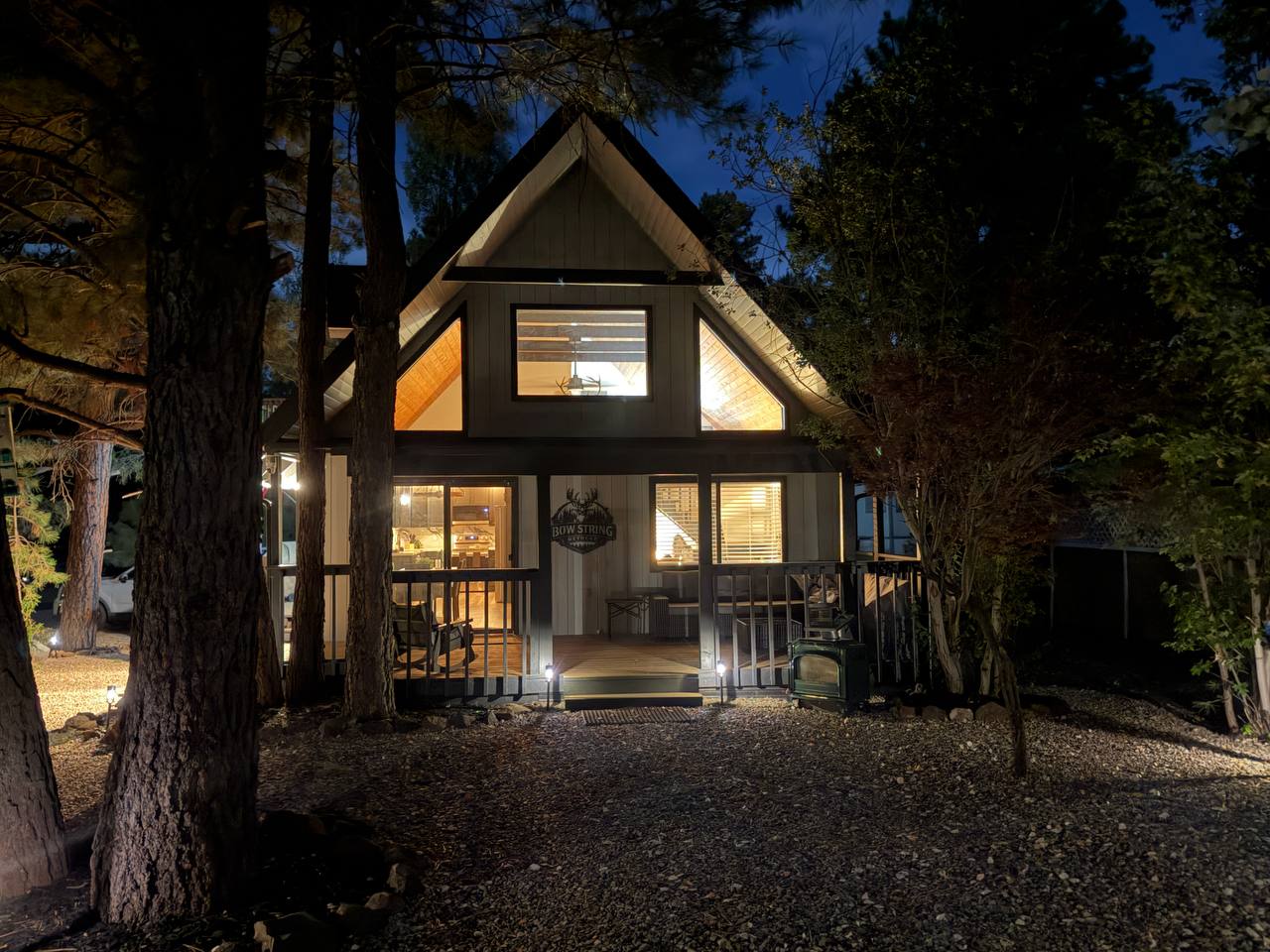 Cabin glowing at night through the pines